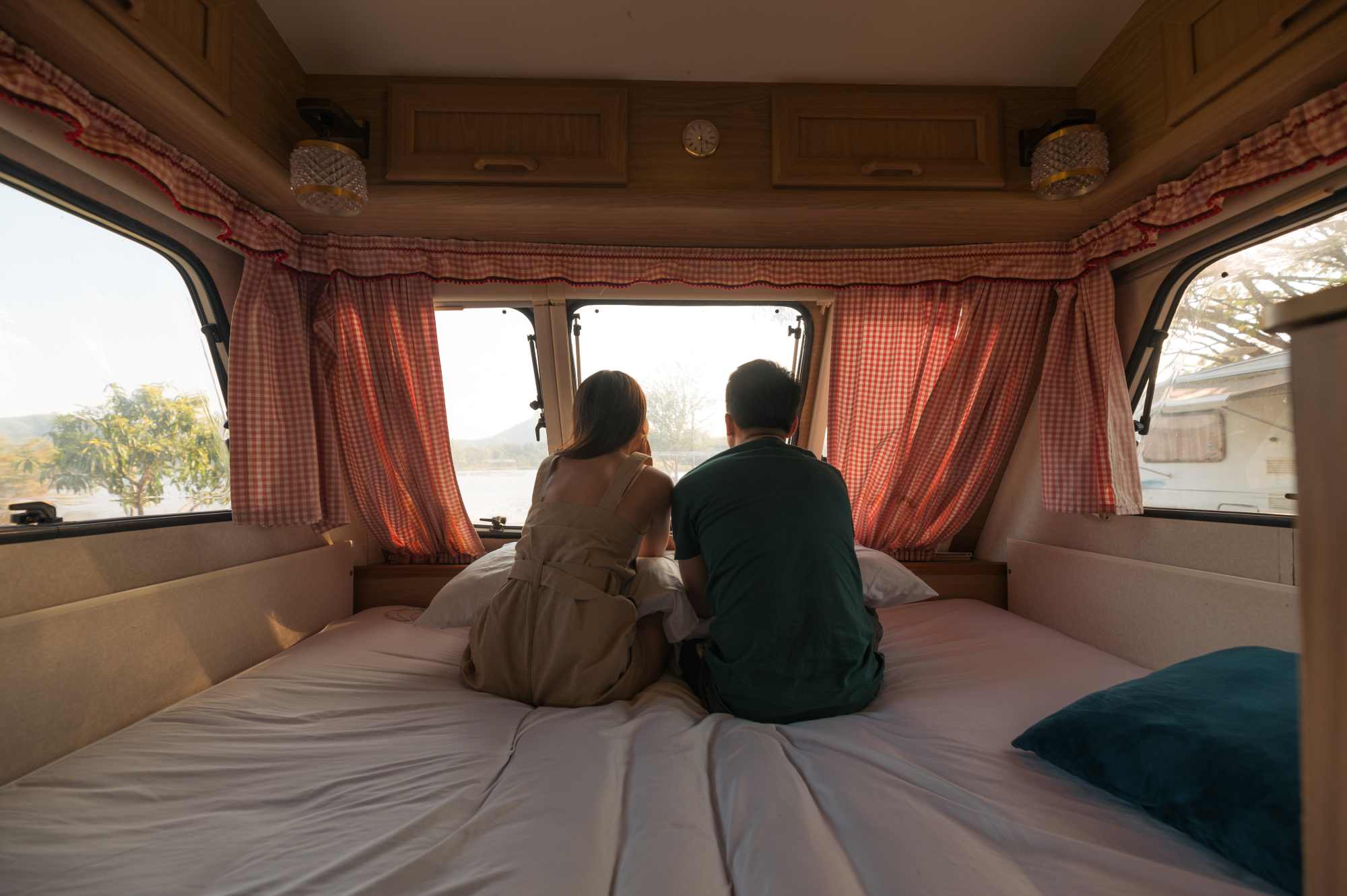 Couple sitting on mattress inside an RV