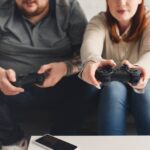 two gamers, male and female, sitting on the couch