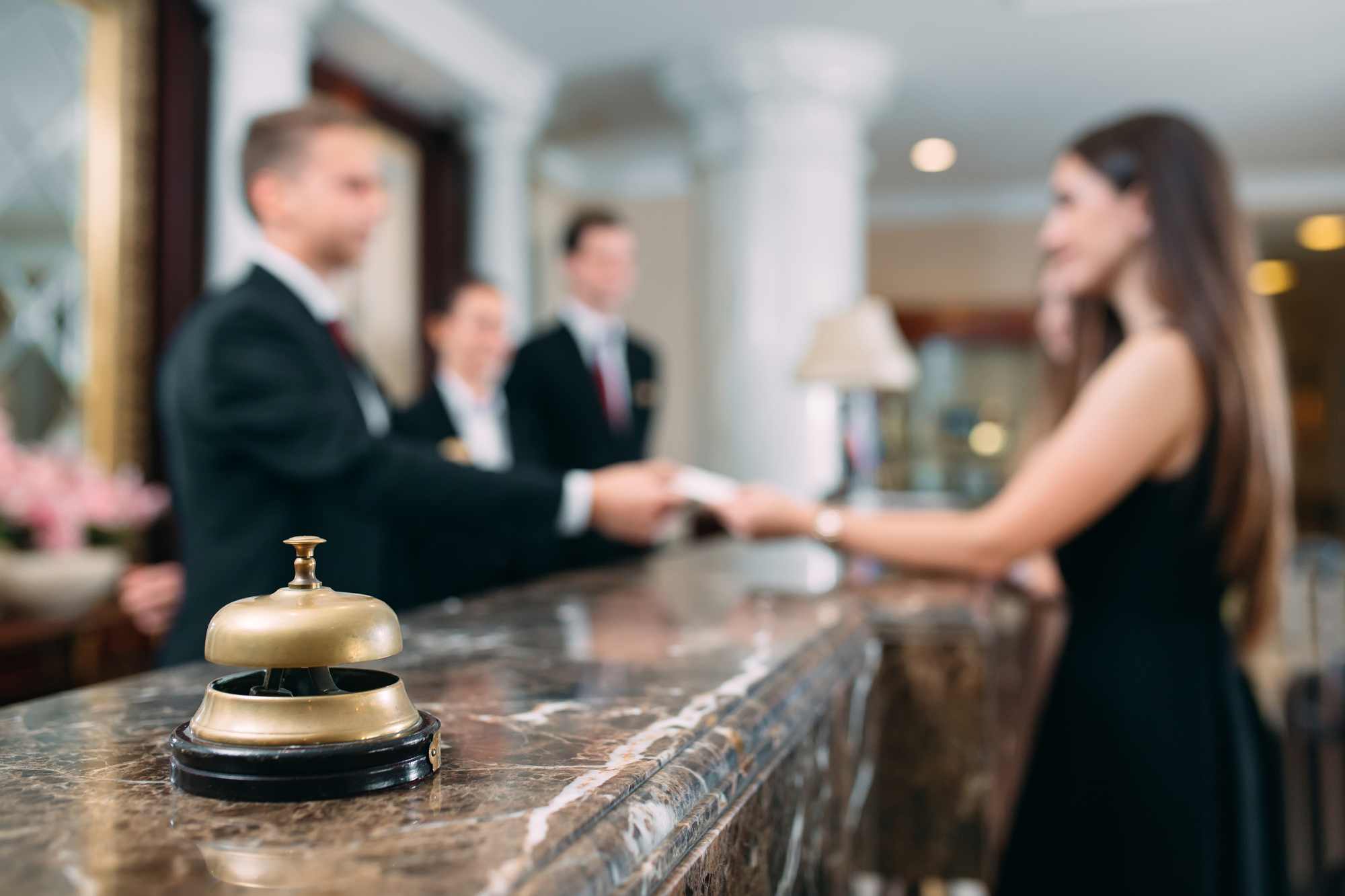 guest receiving something from the hotel reception staff