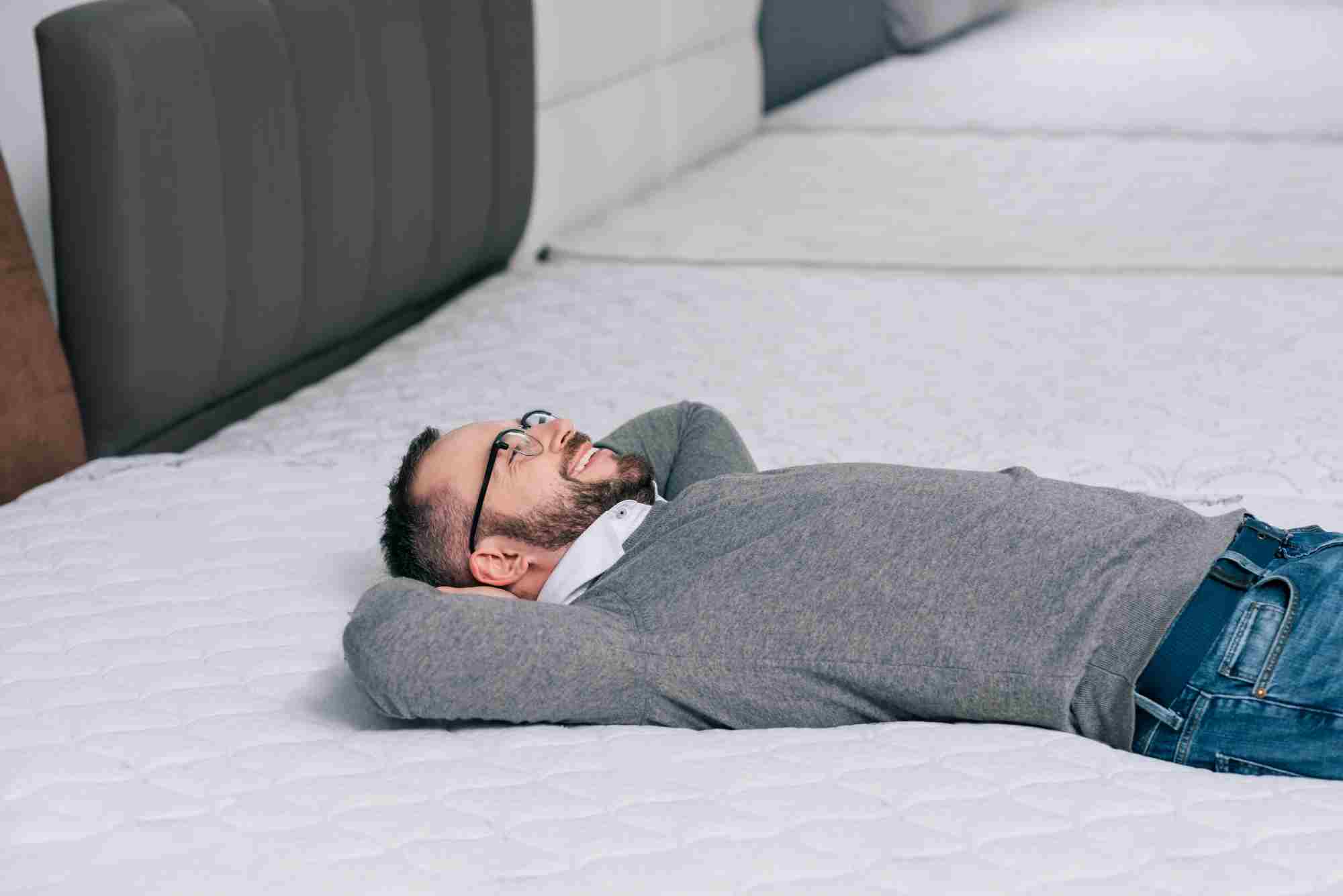 man lying on a mattress looking satisfied