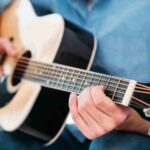 person playing an acoustic guitar