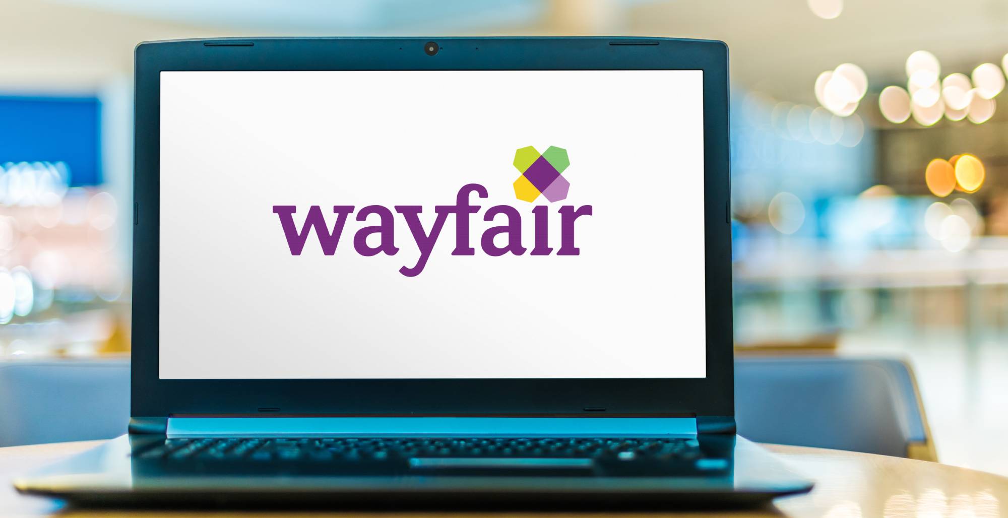 A laptop showing the wayfair website with the background blurred