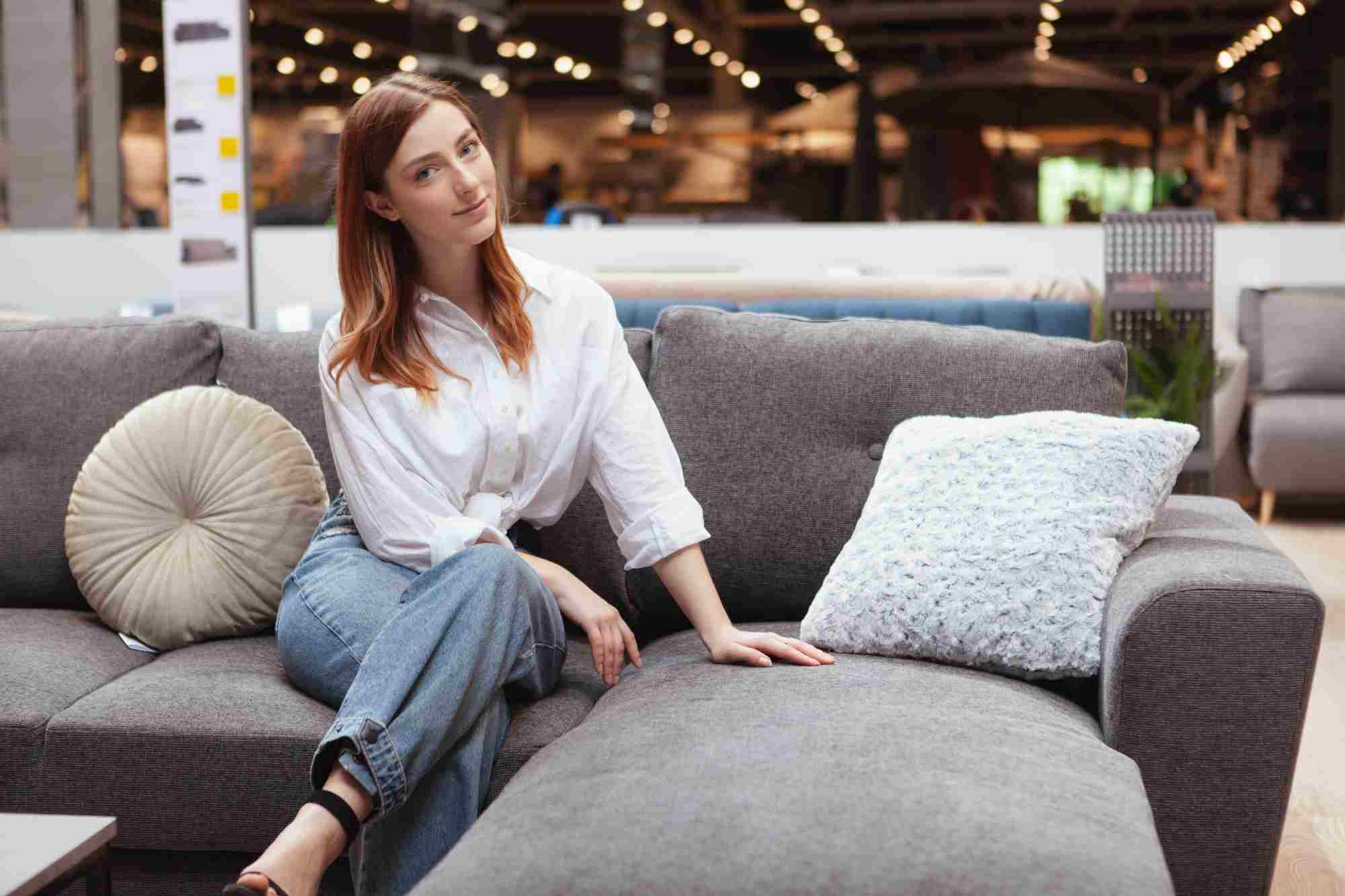 woman testing a sofa in a furniture store