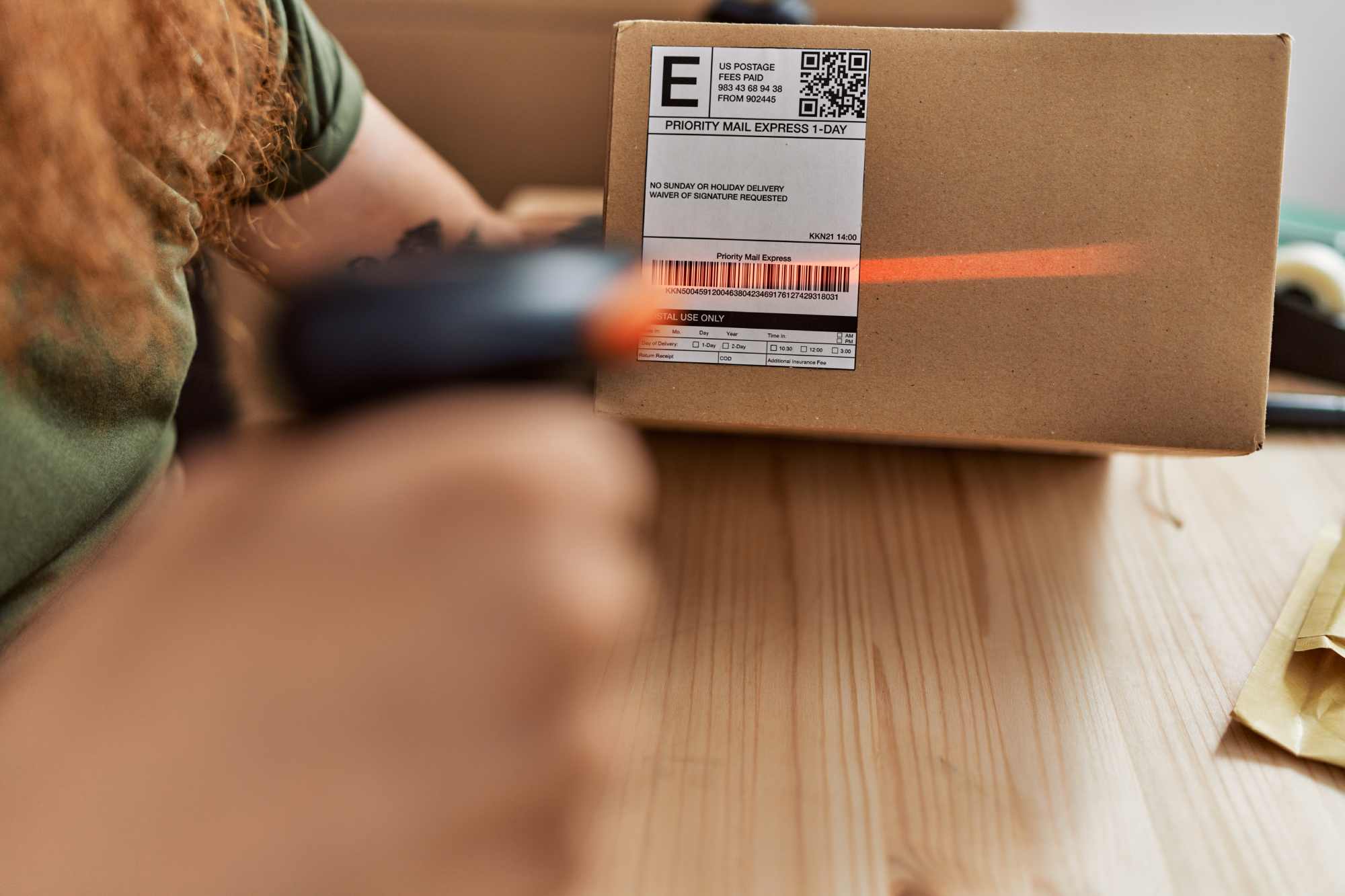 Young redhead man business worker scanning package at office